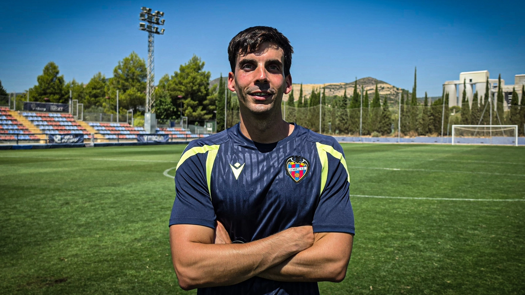 Manu Martínez posa con la camiseta de entrenamiento del Levante UD Femenino en un campo de fútbol